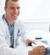 Photo: Smiling doctor in hospital doing paperwork Smiling doctor in hospital doing paperwork