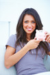 Happy young beautiful woman holding a piggy bank