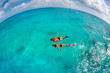Photo en ligne au meilleur prix couple snorkeling in turquoise waters with black swimwear