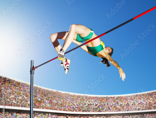Photo: Athlete high jumping in an arena Athlete high jumping in an arena