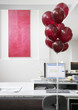 Empty desk with red balloons tied to chair