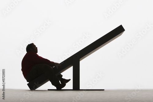 Photo: Large man on unbalanced plank Large man on unbalanced plank