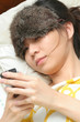 Young girl texting right after awake (side view)