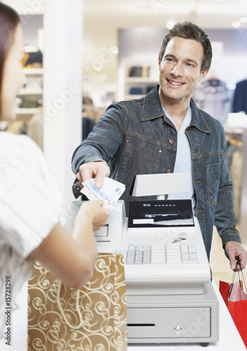 Photo: Man paying for items at a cashier in store Man paying for items at a cashier in store