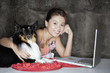 Woman with dog and laptop indoors