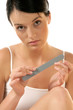 Portrait of young woman buffing her nails