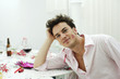 Man with lipstick on cheek leaning on table