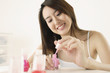 Woman painting fingernails indoors