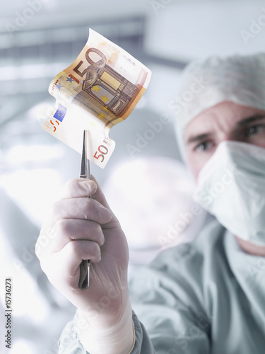 Foto: Doctor holding a fifty euro banknote with tweezers Doctor holding a fifty euro banknote with tweezers