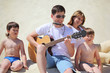 guy in sunglasses plays guitar and  lip accordion  with children