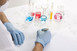 scientist man writing in notebook with testtubes on the table