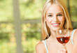 Young smiling woman with glass of red wine, indoors Young smiling woman with glass of red wine, indoors
