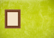 Grunge green stucco wall with empty picture frame