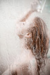 showering woman shot from behind glass showering woman shot from behind glass
