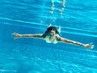 Girly taucht mit ausgebreiteten Armen im Pool