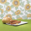 Wiener with mustard and bread roll on table