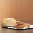 Wieners in plate with dollop of mustard and roll