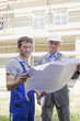 Architect and Construction worker holding construction plan