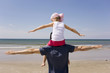 Germany, Baltic sea, Father carrying daughter (6) on shoulders, rear view
