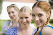Germany, Bavaria, Upper Bavaria, Three women in traditional costumes, smiling, portrait
