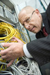 Germany, Munich, Business man checks connectivity on a computer server rack