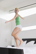 Woman jumping on the bed