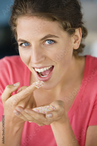 Photo: Woman eating colored sugar granules Woman eating colored sugar granules