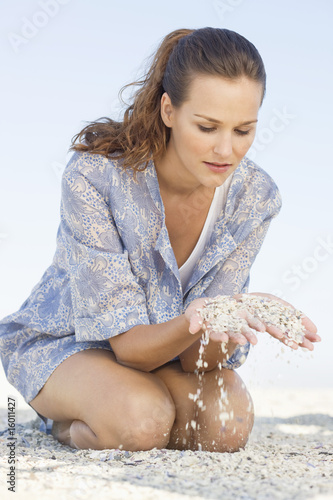 Photo: Woman playing with sand on the beach Woman playing with sand on the beach