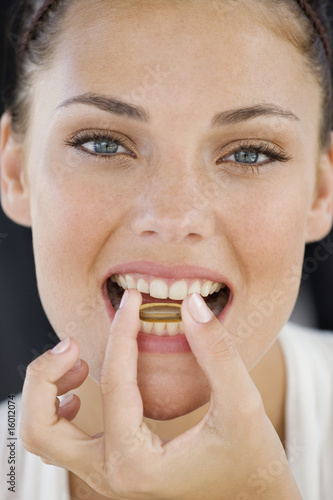 Photo: Portrait of a woman taking an Omega-3 capsule Portrait of a woman taking an Omega-3 capsule