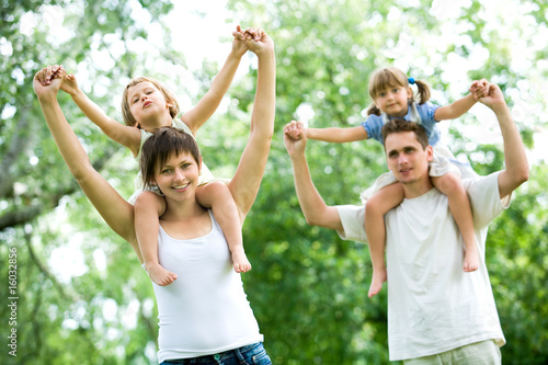 Photo: Couple giving children piggyback rides Couple giving children piggyback rides