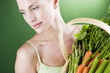 A young woman holding a basket full of vegetables