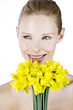 A portrait of a woman holding a bunch of daffodils, smiling