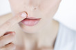 A young woman touching her upper lip, close-up
