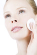 A portrait of a young woman cleansing her face, close-up