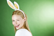 A young blonde woman wearing rabbit ears, winking