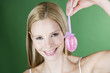 A portrait of a young blonde woman holding a pink Easter egg
