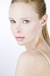 A portrait of a young blonde woman looking over her shoulder