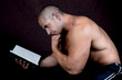 Young attractive male bodybuilder reading the book Young attractive male bodybuilder reading the book
