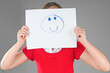 Girl hiding behind happy face