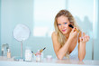 Cute female applying make up using a brush