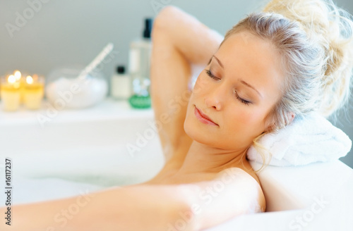 Photo: Beautiful young woman bathing in a tub Beautiful young woman bathing in a tub