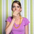 Teenage girl (16-17) covering mouth with hand, portrait