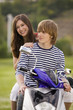 Young couple sitting on moped, smiling