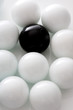 Black ball between several white balls, close-up