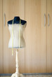 Mannequin and tape measure in front of wardrobe