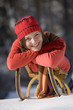 Young woman lying on sledge, portrait, smiling
