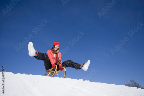 Foto: Young woman riding sledge Young woman riding sledge