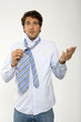 Young businessman getting ready, adjusting tie, close-up, portrait