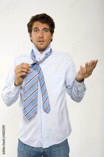Photo: Young businessman getting ready, adjusting tie, close-up, portrait Young businessman getting ready, adjusting tie, close-up, portrait