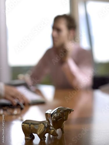 Photo: Figurines of bull and bear on desk (focus on foreground) Figurines of bull and bear on desk (focus on foreground)